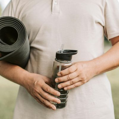 Close-up of a yoga mat and a water bottle in a cozy room.